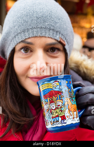 Frau trinkt Traditonal Glühwein trinken am Weihnachtsmarkt in Köln Stockfoto