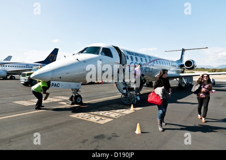 Aeromexico Connect gut aussehend Embraer 145 Business-Jet Flugzeug entlädt Passagiere direkt auf Asphalt am Bahias de Huatulco Flughafen Stockfoto