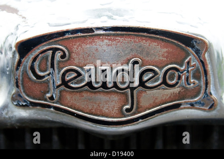 Ein Vintage Peugeot-Emblem auf der Vorderseite eines alten Peugeot Autos bei einer Autoshow. Stockfoto