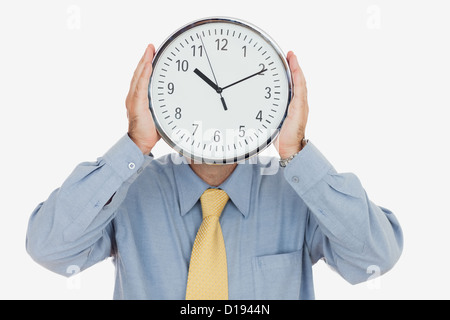 Geschäftsmann Betrieb Uhr vor Gesicht Stockfoto