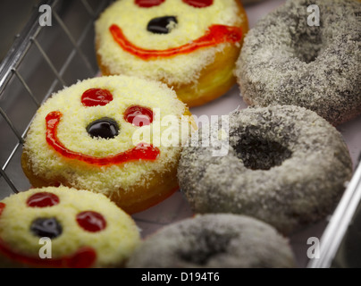 Krapfen - Smileys auf einem Regal in Konditorei Stockfoto