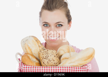Glückliche junge Frau mit Korb voll Brot Stockfoto