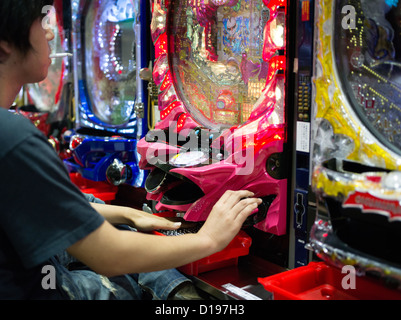 Japanisch Mann spielen Pachinko und Rauchen in Shinjuku-Tokio Stockfoto