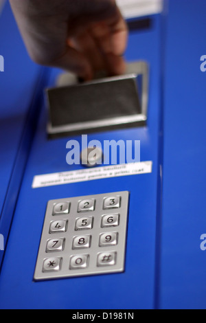 Hand, die Münze in Automaten einfügen Stockfoto