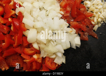 Lebensmittel-Pyramide von Paprika, Zwiebeln, Tomaten und Knoblauch auf Marmor Schneidebrett Stockfoto