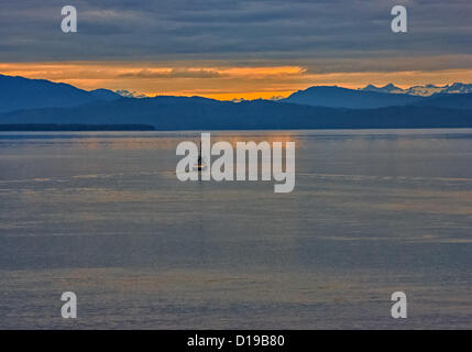 6. Juli 2012 beginnt - Inside Passage, Alaska, US - A kommerzielle Fischerboot in der Inside Passage wie die Sonne hinter den Bergen Coastal Range steigen. Angeln fährt einen großen Teil der Wirtschaft Alaskas. Die Inside Passage, prägten eine Küstenstraße für hochseetaugliche Schiffe riesigen Gletschern Millionen von Jahren. Der Alaska-Teil 500 Meilen (800Â km) erstreckt sich von Norden nach Süden und 100 Meilen (160Â km) von Osten nach Westen mit 15.000 Meilen (24, 000Â km) der Küstenlinie und Tausende von Buchten. (Kredit-Bild: © Arnold Drapkin/ZUMAPRESS.com) Stockfoto