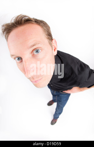 Junger Mann stehend in weiß Stockfoto