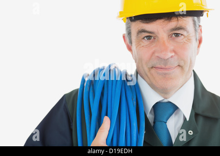 Mechaniker mit gerollten Draht trägt Helm Stockfoto