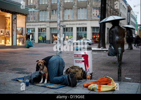 Ein Mann deckt seinen Hund in Decken bevor er fragt Passanten für Spenden an die Innenstadt von Hannover, Deutschland, 11. Dezember 2012. Temperaturen unter Null Grad Celsius-Marke gefallen. Foto: Emily Wabitsch Stockfoto