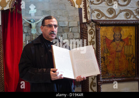 Vater Nadim Shakur präsentiert eine arabische Bibel verwendet in Gemeinschaft gebeten an der Mi'ilya Kirche der Mariä Verkündigung. Mi'ilya, Israel. 11. Dezember 2012.   Mi'ilya, einem arabischen Dorf im westlichen Galiläa hat eine Bevölkerung von 3.100 melkitischen Christen gehören zur griechisch-katholischen Kirche über ihre Geschichte, 1. Jahrhundert Christen von Antiochia, Türkei, wo das Christentum, von St. Peter eingeführt wurde. Stockfoto