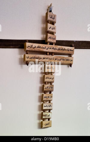 Ein Kreuz mit arabischen Inschriften hängt an einer Wand in der Heimat der Layous Familie. Mi'ilya, Israel. 11. Dezember 2012.   Mi'ilya, einem arabischen Dorf im westlichen Galiläa hat eine Bevölkerung von 3.100 melkitischen Christen gehören zur griechisch-katholischen Kirche über ihre Geschichte, 1. Jahrhundert Christen von Antiochia, Türkei, wo das Christentum, von St. Peter eingeführt wurde. Stockfoto