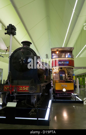 Dampf Lok und alte Straßenbahn im neuen Transportmuseum im Riverside Museum in Glasgow; Die Architektin Zaha Hadid Stockfoto