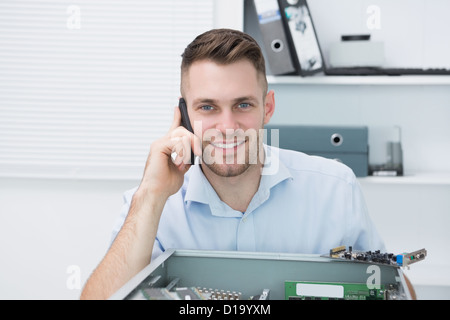 Porträt des Lächelns Informatiker auf Abruf vor der offenen cpu Stockfoto
