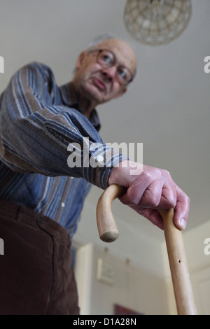 Älterer kaukasischen Mann zu Hause, Mobilitätsmanagement mit Gehstock, Suffolk, UK Stockfoto