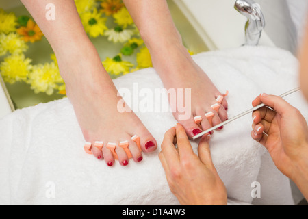 Frau Polieren der Fußnägel im Wellnesscenter Stockfoto