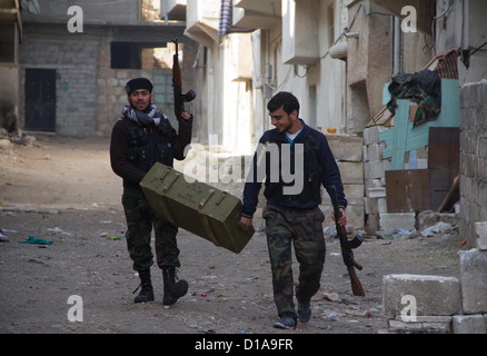 29. November 2012 - Aleppo, Syrien: Freie Syrische Armee Kämpfer tragen eine Munitionskiste in Amaria. Stockfoto