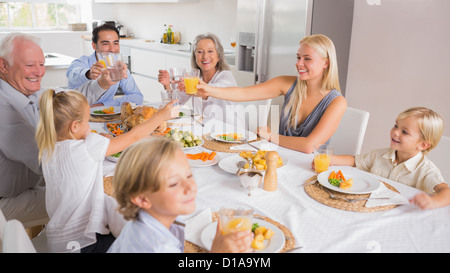 Glückliche Familie erhöhen ihre Gläser Stockfoto