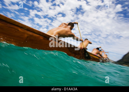 Hawaii, Oahu, Waimanalo, männliche Outrigger-Kanu-Team hart durch blau-grüne Meer paddeln. Stockfoto