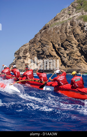 Hawaii, Oahu, Hawaii Kai Outrigger Canoe Team paddeln hart durch Blue Ocean. Stockfoto