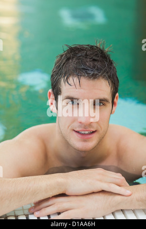 Schöner Mann im Pool Stockfoto