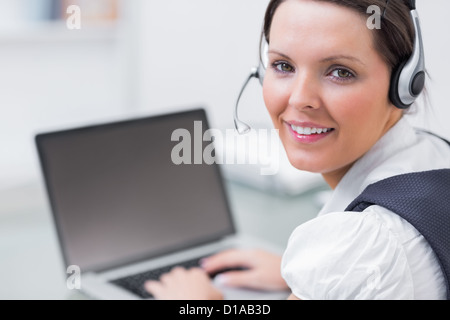 Porträt des Business-Frau trägt Kopfhörer und Laptop verwenden Stockfoto