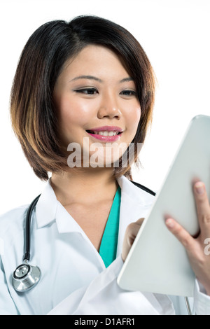 Porträt von einer chinesischen Ärztin mit Hilfe einer digitalen-Tablets & tragen einen Kittel und Stethoskop hautnah. Stockfoto
