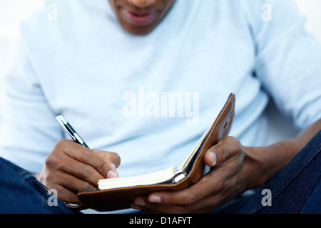 Nahaufnahme der jungen afrikanischen Mann etwas zu schreiben, im Editor Stockfoto