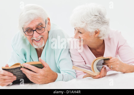 Glücklich Mann und Frau im Bett lesen Stockfoto