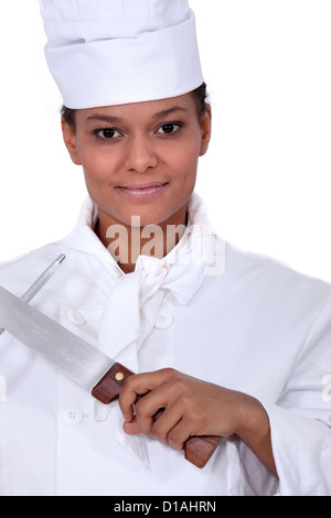 Köchin Schärfen eines Messers Stockfoto