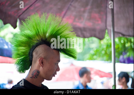 Thai Mann mit grünen Haaren und eine Tätowierung auf dem Sonntagsmarkt Stockfoto