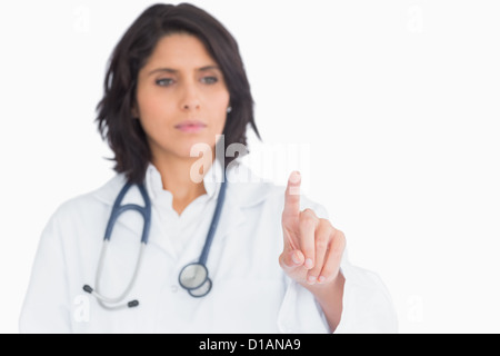 Hübsche Arzt zeigen mit dem Finger in der Luft Stockfoto