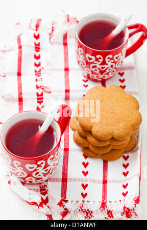 Weihnachten-Glühwein in zwei kleine rote Tassen und Lebkuchen vor weißem Hintergrund Stockfoto
