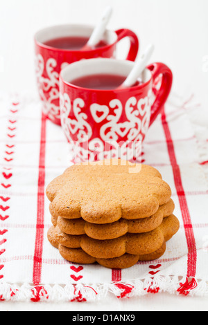 Lebkuchen und zwei kleine Tassen Weihnachten Glühwein Wein ruht auf Teatowel vor weißem Hintergrund Stockfoto