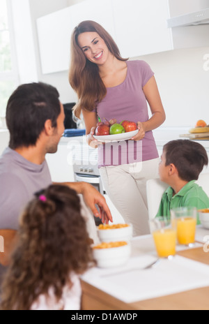 Mutter bringt Äpfel zum Frühstück Stockfoto