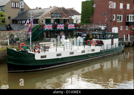 Ein großes Haus-Boot, Poseidon, festgemacht an der Seite der Fishemens Wharf Resaurant, auf dem Fluss Stour Sandwich Kent. Stockfoto