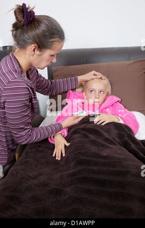 Mutter Überprüfung unwohl Mädchen Temperatur zu Hause Stockfoto