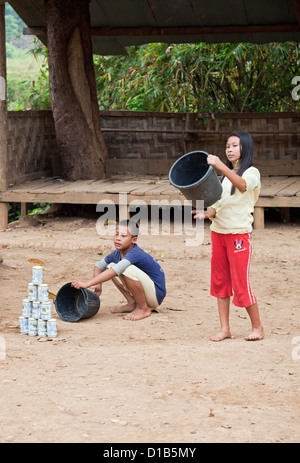 Kinder aus der Kayan Minderheit ein Spiel ähnlich wie Cricket, Huai Seau Tao, Mae Hong Son Provinz, Thailand Stockfoto