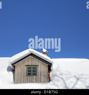 Das alte Holzdach bedeckt mit Schnee und blauer Himmel Stockfoto