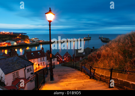 Blick auf die Küste Stadt Whitby in der Dämmerung, mit Blick auf die Hafeneinfahrt von 199 Stufen. Stockfoto