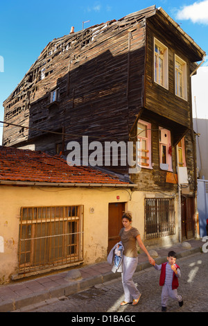 Frau und Kind zu Fuß durch alte heruntergekommen historischen osmanischen Holzhaus in Istanbul Türkei Stockfoto