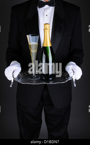 Nahaufnahme von einem Kellner mit einer Flasche und Rauchfang Champagner auf einem silbernen Tablett. Stockfoto