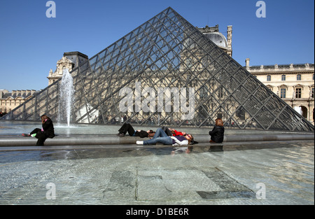 Paris, Frankreich, Aalen sich Menschen vor die Glaspyramide des Louvre Stockfoto