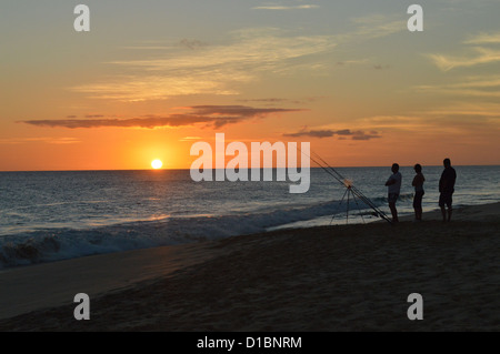 Angeln in der Dämmerung, drei Fischer beobachten dort Linien vom Strand Praia de Locacao Boa Vista bei Sonnenuntergang, Kapverdische Inseln. Stockfoto