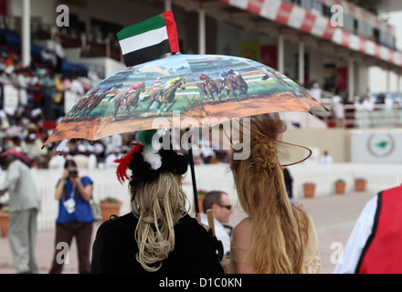 Dubai, Vereinigte Arabische Emirate, Frauen mit Hut und Sonnenschirm auf der Rennbahn Stockfoto