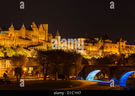 Mittelalterliche Festung auf einem Hügel und Brücke in Carcassonne Frankreich beleuchtet in der Nacht Himmel vom Riverfront Park unten gesehen Stockfoto