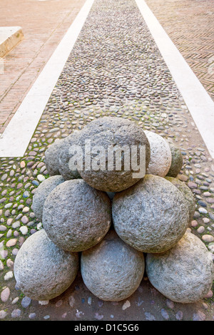 alte steinerne Kanonenkugel im Innenhof der Burg Estense in Ferrara, Italien Stockfoto