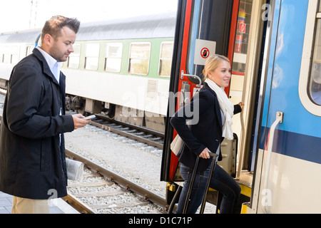 Frau, die immer auf Zug Mann SMS Telefon Pendler Reise Treppen Stockfoto
