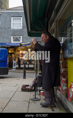 Totnes, Devon, England. 12. Dezember 2012. Busker draußen, eine Buchhandlung, die Trompete zu spielen. Stockfoto