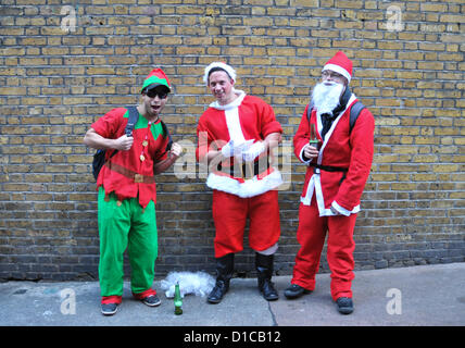 Leicester Square, London, UK. 15. Dezember 2012. Zwei Weihnachtsmänner und eine Elfe auf Santacon. Santacon London 2012, Hunderte von Menschen verkleidet als Weihnachtsmann, Elfen und sogar Bäume versammeln und Parade rund um London und Kneipen auf dem Weg zu besuchen. Bildnachweis: Matthew Chattle / Alamy Live News Stockfoto