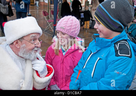 Lichfields award Gewinner Stadtausrufer Ken Knowles als Weihnachtsmann verkleidet im Gespräch mit Kindern in Lichfield Marktplatz Staffordshire England 15. Dezember 2012 Stockfoto